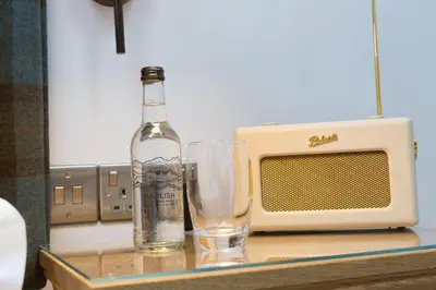 a bottle of champagne and a glass on a table with a microwave at Pentonbridge Inn - Restaurant with Rooms in Carlisle