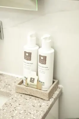 a counter with three bottles of toiletries on it at Pentonbridge Inn - Restaurant with Rooms in Carlisle