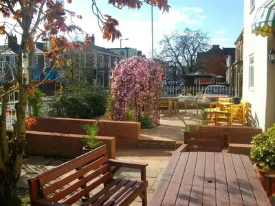 a patio with benches and flowers and tables at Arkale Lodge in Carlisle
