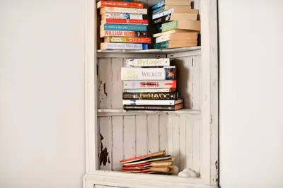 a book shelf filled with books in a room at Longhill Farmhouse in Whithorn