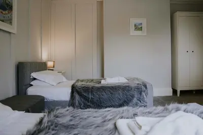 a hotel room with two beds and a chair at Troutbeck Inn in Troutbeck