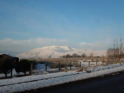 a snowy road with a mountain in the background at Troutbeck Inn in Troutbeck