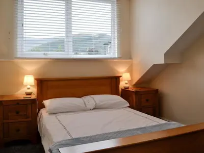 a bedroom with a bed with a window and a staircase at Walla Crag in Keswick