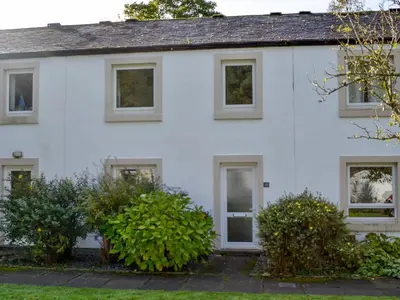 a white house with bushes in front of it at Philip's Cottage in Keswick
