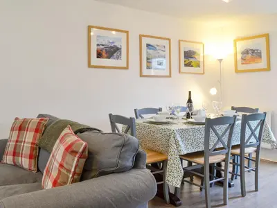 a dining room with a table and chairs and a couch at Philip's Cottage in Keswick