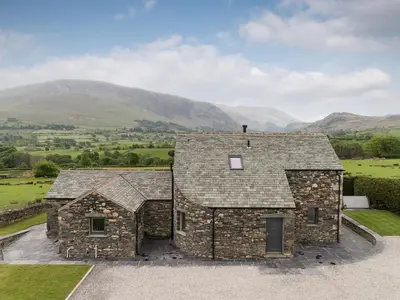 an image of a stone house with mountains in the background at The Hoggest in Threlkeld