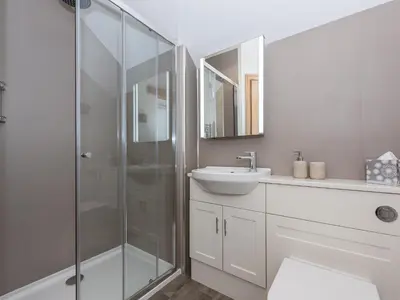a bathroom with a glass shower and a sink at The Hoggest in Threlkeld