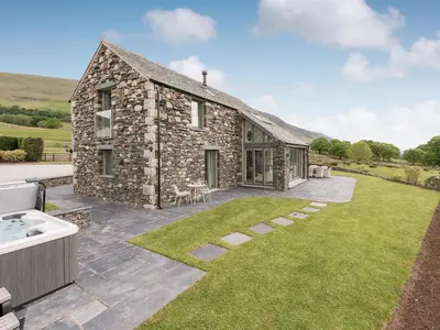 an external view of a stone house with a garden at The Hoggest in Threlkeld
