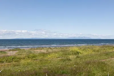 a beach with the ocean in the background at Links View - Donnini Deluxe in Prestwick