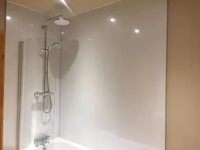 a shower with a glass door in a bathroom at Ewes Water Log Cabins in Langholm