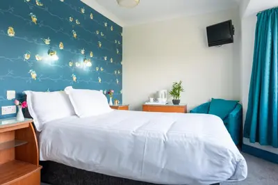 a bedroom with a bed and a blue wall at Rickerby Grange in Keswick