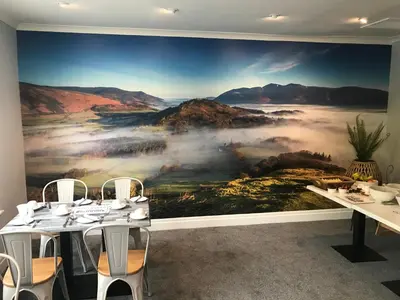 a dining room with a large painting on the wall at Rickerby Grange in Keswick