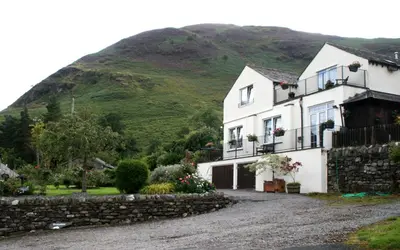a white house with a hill in the background at StoneyGill in Keswick