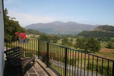 a bench on a balcony with a view of mountains at StoneyGill in Keswick