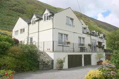 a white house with a hill in the background at StoneyGill in Keswick