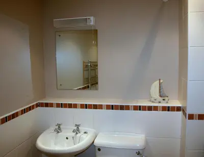a bathroom with a sink and a toilet and a mirror at StoneyGill in Keswick