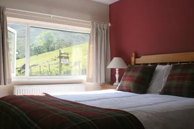a bedroom with a bed and a large window at StoneyFell in Keswick