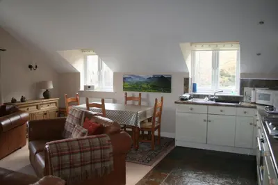 a kitchen and living room with a table and chairs at StoneyFell in Keswick