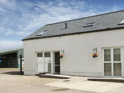 a white building with windows and flowers on it at The Loft in Annan