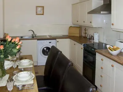 a kitchen with a table and a kitchen with a dishwasher at The Loft in Annan