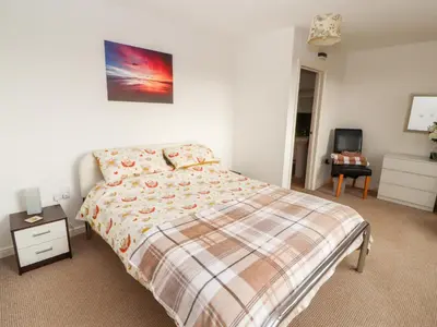 a bedroom with a bed and a desk and a chair at Woodpecker in Ivegill