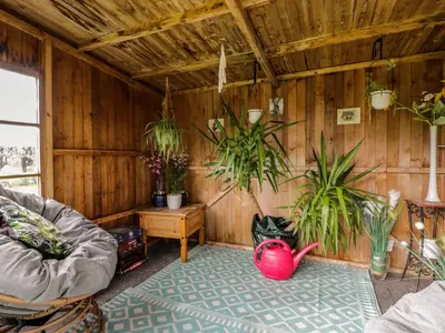 a room with wooden walls with plants in it at Rose Cottage in Stranraer