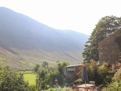 a view of a mountain with a table and an umbrella at The Hayloft in Keswick
