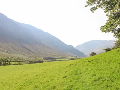 a green grassy hill with mountains in the background at The Hayloft in Keswick