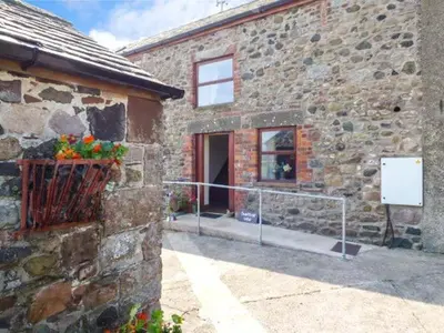 a stone building with a door and a window at Surprise View in Holmrook