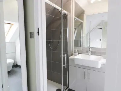 a bathroom with a white sink and a shower at The Bothy in Mainsriddle