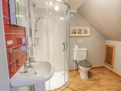 a bathroom with a shower and a sink and a toilet at The Dairy in Newton Stewart