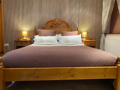 a bedroom with a large bed with two night stands at Stable Cottage in Wigton