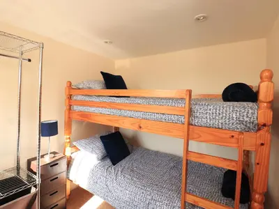 two bunk beds in a room with a mirror at Stable Cottage in Wigton