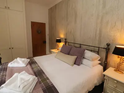 a bedroom with a large white bed with pillows at North Lodge in Annan