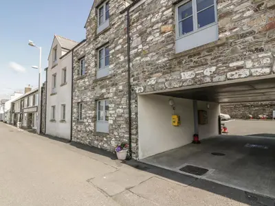 a brick building with a garage on a street at The Moorings in Isle of Whithorn