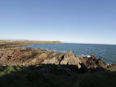 a group of rocks on the shore of the ocean at The Moorings in Isle of Whithorn