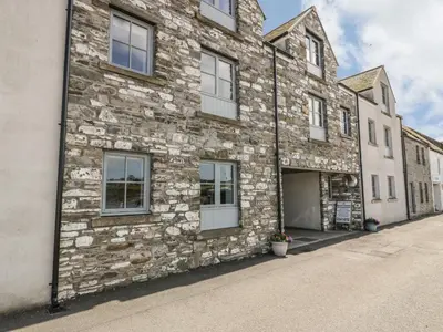 an old stone building with a garage at The Moorings in Isle of Whithorn