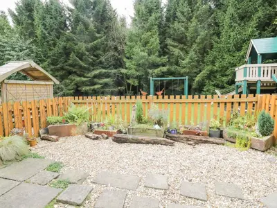 a backyard with a wooden fence and a garden at The Cottage at Graysondale Farm in Cockermouth