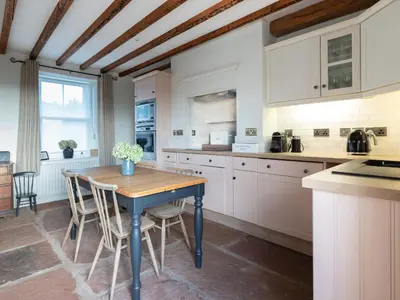 a kitchen with a table and chairs in a room at Stag Cottage in Penrith