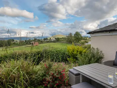 a view of a garden with a wooden picnic table at Stag Cottage in Penrith