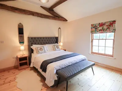 a bedroom with a large bed and a window at Rose Cottage in Crosby