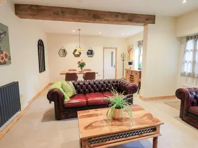 a living room with a leather couch and a table at Rose Cottage in Crosby