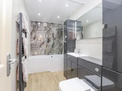 a bathroom with a shower and a sink and a toilet at Maple Cottage in Keswick