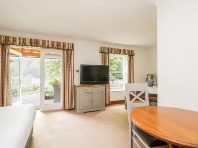 a living room with a table and a tv and a table and a dining room at Thirlmere Suite in Thirlmere