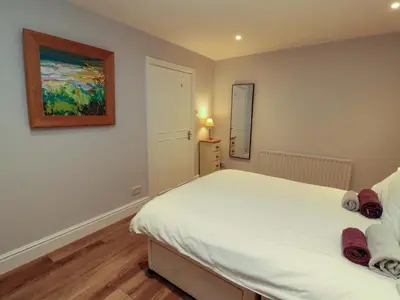 a bedroom with a bed and a painting on the wall at Archers in Keswick