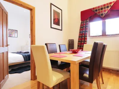 a dining room with a table and chairs and a bed at Keswick Loft in Keswick