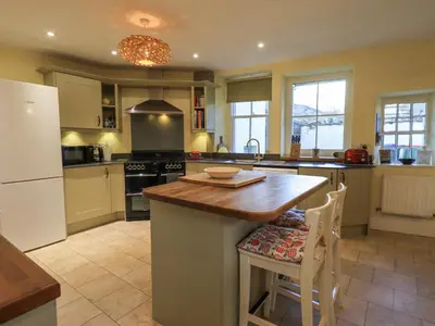 a kitchen with a island with a wooden counter top at Greta Mill in Keswick
