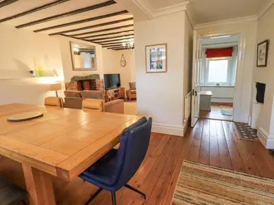 a dining room and living room with a wooden table and chairs at Greta Mill in Keswick
