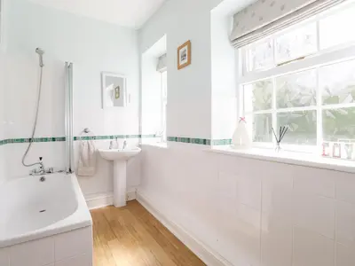 a white bathroom with a tub and a sink at How End in Braithwaite