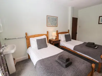 two beds in a room with a sink and a sink at Pelham House in Keswick